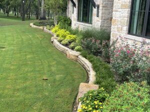 Stone border with accent boulders in front of landscaping beds